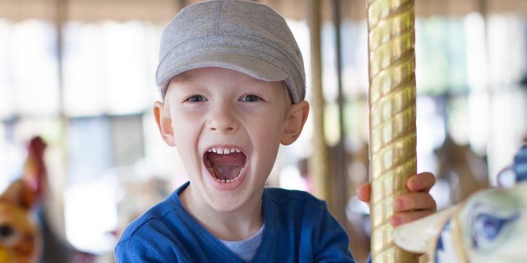child enjoying himself on a carousel