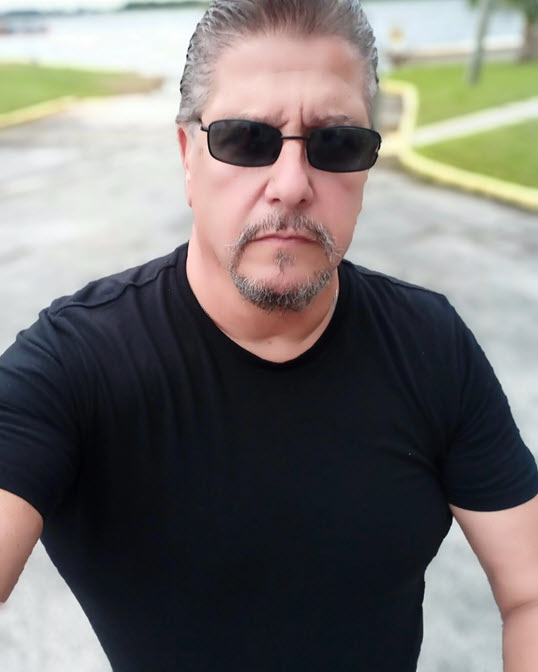 Peter LaPorta, best-selling author and motivational speaker, pictured in black T-shirt on street.